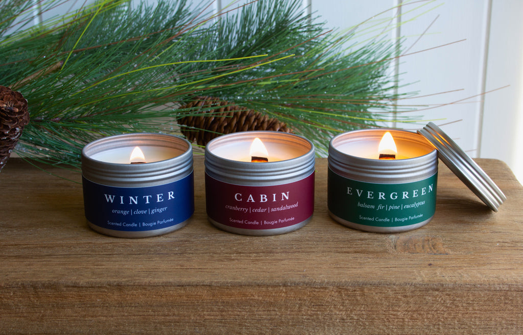 Holiday Collection from Brightfield, Gingerbread candles burning with a gingerbread cookie beside them and holiday greenery, and Christmas scented candles, holiday candles, wood wick candles, Gingerbread candle, best Christmas candles