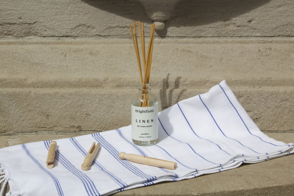 Reed diffusers from Brightfield, Linen Reed Diffuser on a linen tea towel with clothes pegs, clean aesthetic, clean living, wholesale reed diffusers, reed diffuser gift